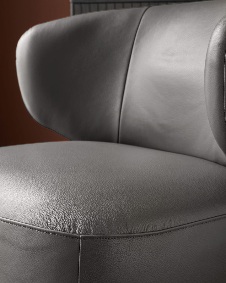 Close-up of a stylish grey leather chair, showcasing the texture and fine stitching details.