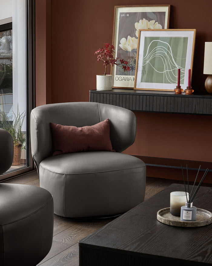 Modern living room with grey leather armchairs, wood-panelled coffee table and wall-mounted shelving unit.