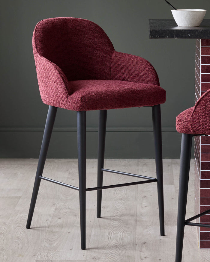 A stylish, claret-coloured bar stool with a comfortable curved back and sleek, black legs. A modern kitchen essential.