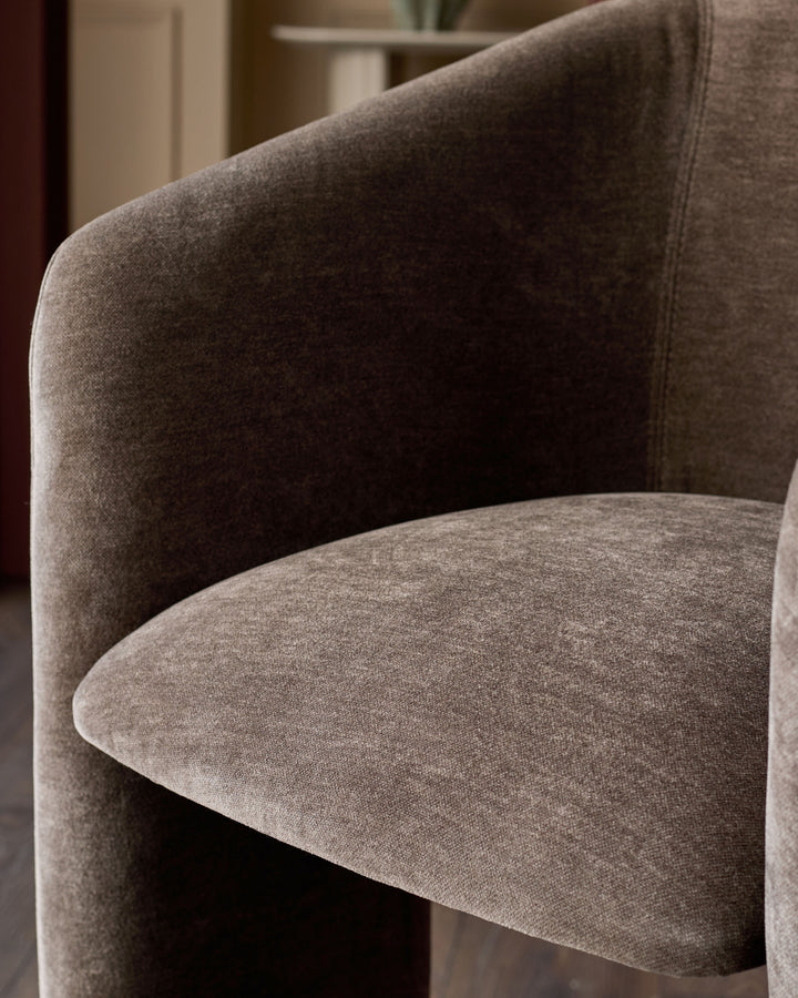 Leighton brushed bronze cantilever bar stool in mocha fabric, showing curved seat and backrest detail from side angle.