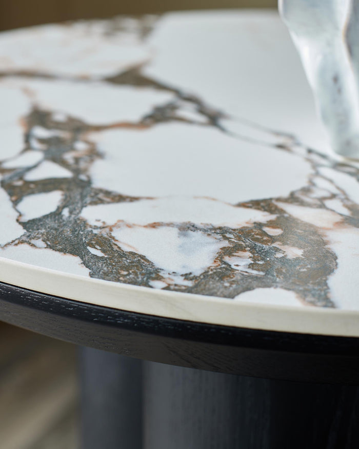 Close-up of a marble-topped side table with a dark wood frame, showcasing the intricate pattern and textures of the materials.