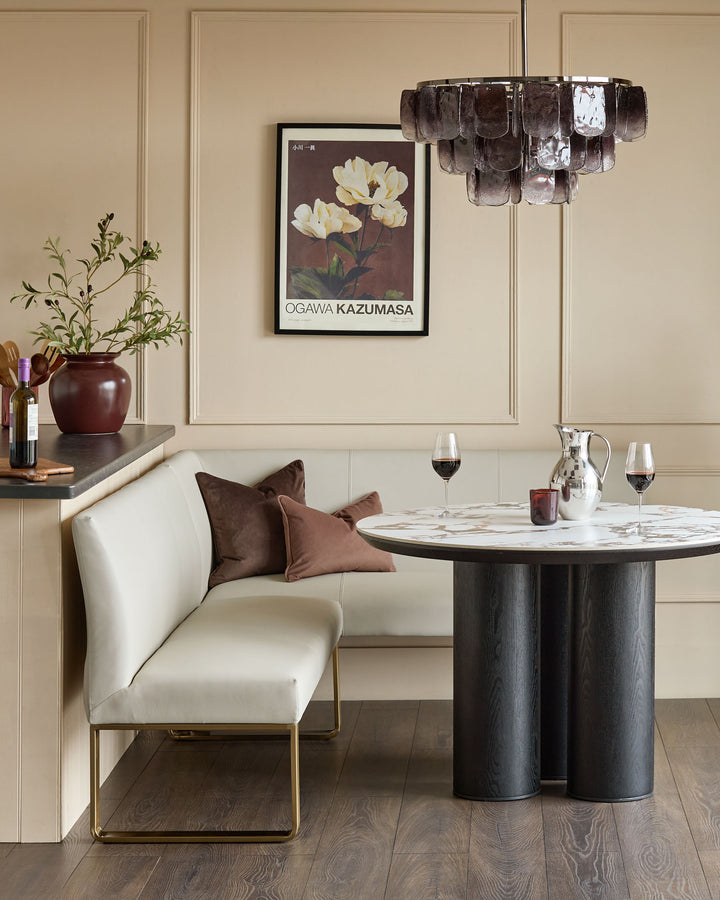 Light grey faux leather corner dining bench with brushed brass legs, shown in modern dining room setting.