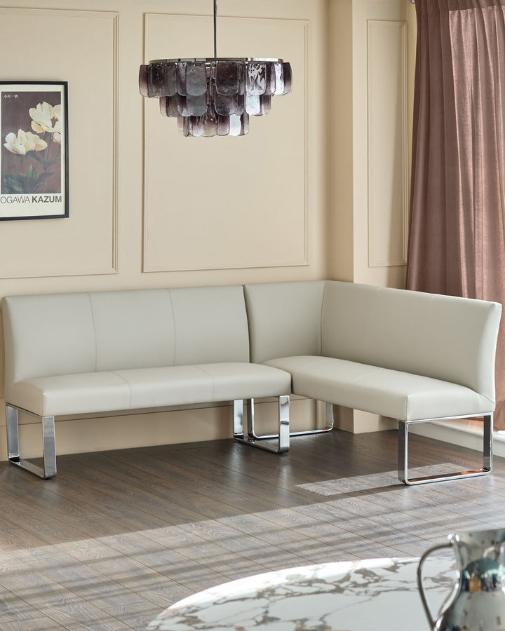 Light grey faux leather corner bench with chrome legs, shown in modern room setting.