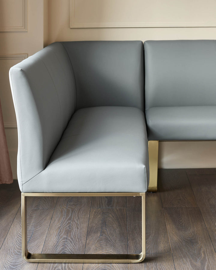 Loop 5-seater right-hand corner dining bench in mid-grey faux leather with brushed brass legs, angled side view.