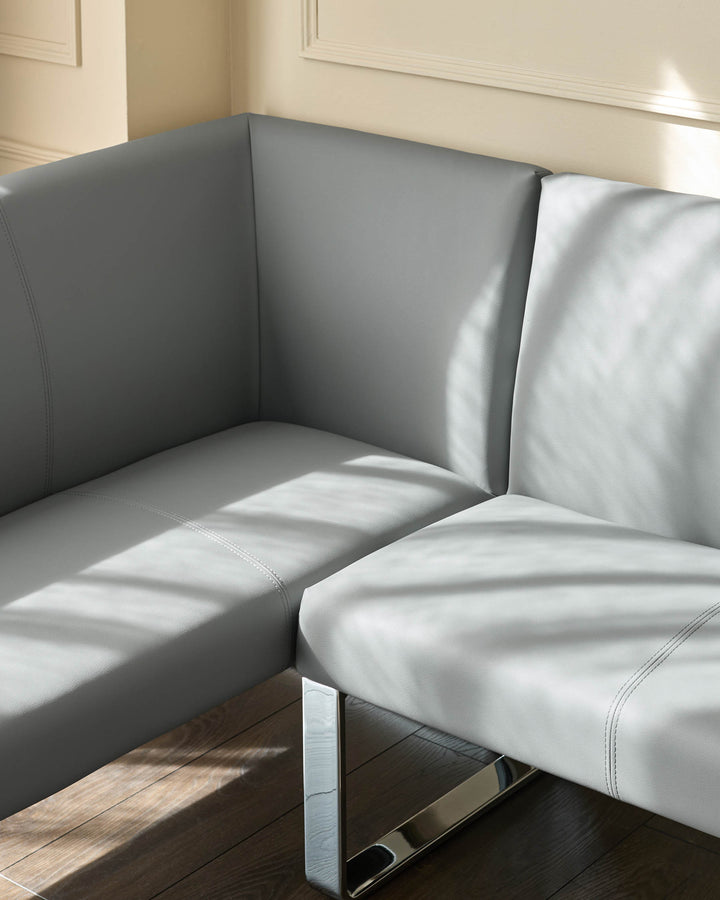 Loop 5-seater left-hand corner dining bench in mid-grey faux leather with chrome legs, angled view.