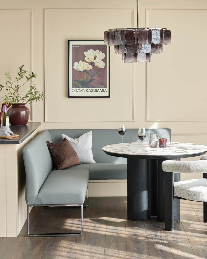 Mid-grey faux leather corner bench with chrome legs, styled in modern dining space.