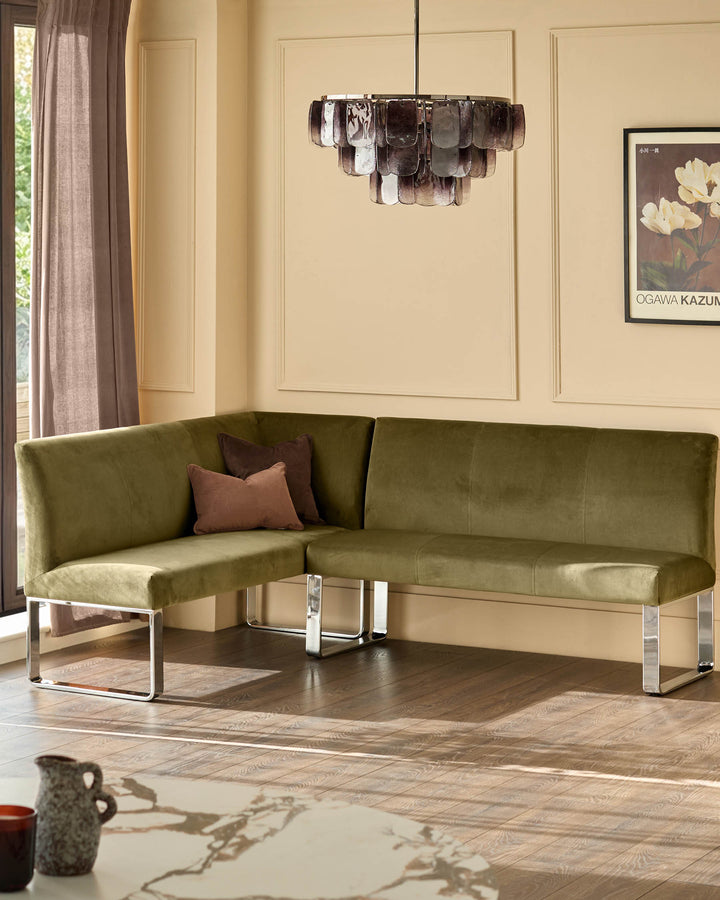 Olive green 5-seater corner bench with chrome legs, styled in a modern living room with pendant light and botanical artwork.
