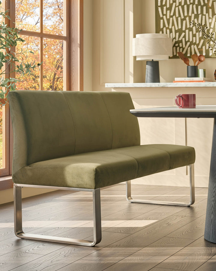 Loop 3-seater velvet bench with backrest in olive green, stainless steel frame, shown in modern living room setting.