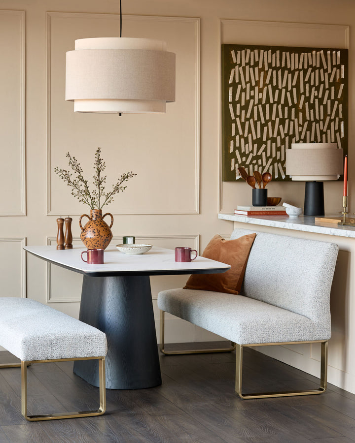 Grey fabric bench with brushed brass legs, shown in modern living room setting.