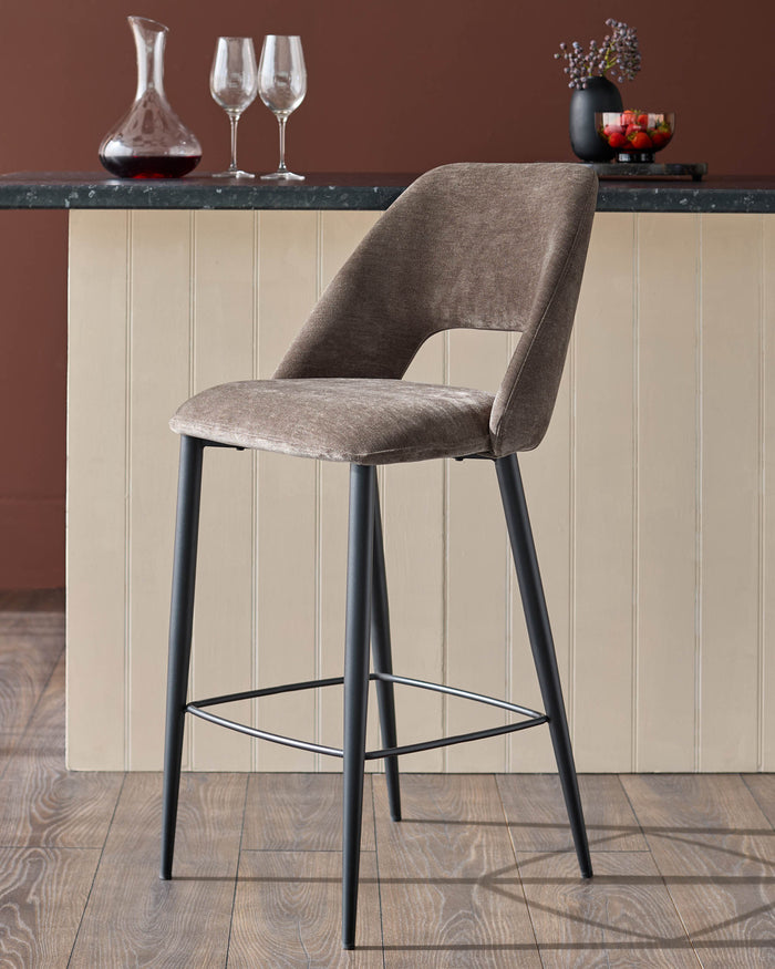Stylish bar stool with a tan fabric seat and black legs. Perfect for kitchen islands and home bars.