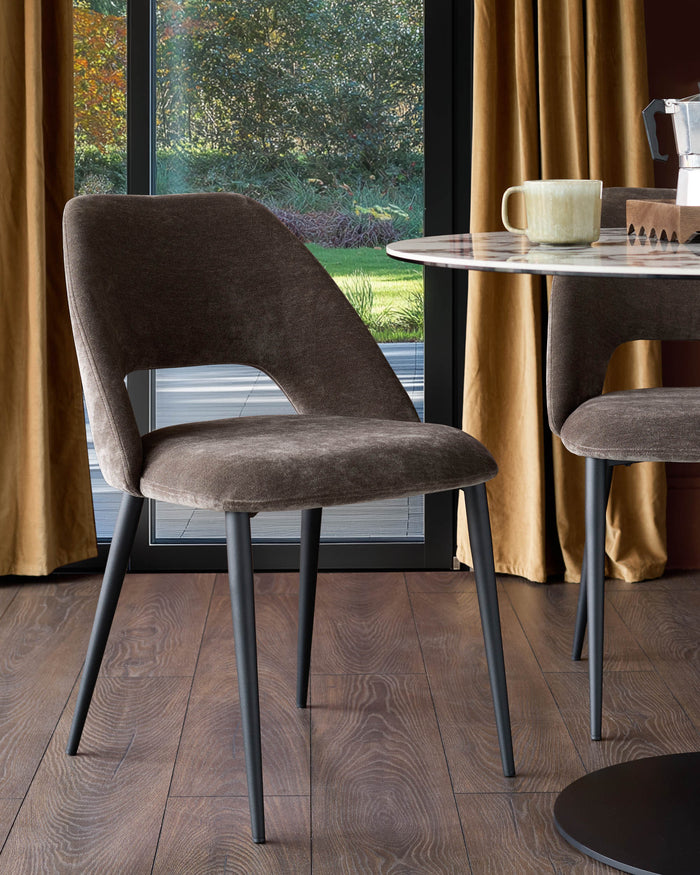 A modern dining scene with a brown velvet chair and marble-topped table, creating a stylish, inviting space.