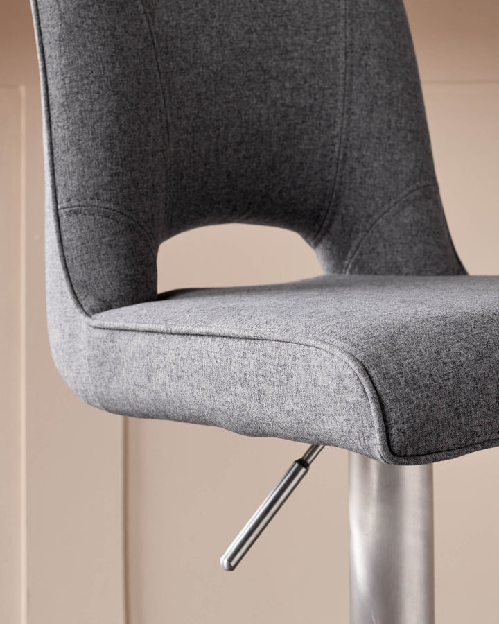 Dark grey fabric gas lift bar stool with curved backrest and chrome metal base, side view.