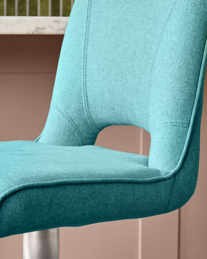 Light teal fabric gas lift bar stool, close-up of curved backrest and seat detail with metal base visible.