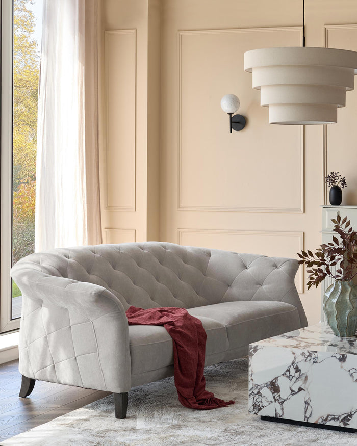 A stylish living room featuring a grey sofa, marble coffee table and modern lighting for a contemporary feel.