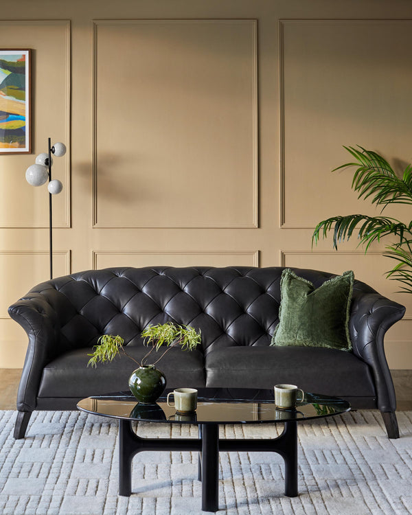 Elegant black leather sofa, marble effect coffee table and neutral rug create a refined, comfortable living space.