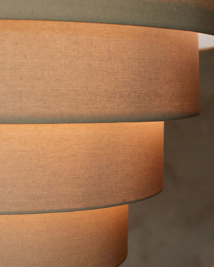 Close-up of a tiered lampshade, showcasing its texture and warm, inviting glow. Modern lighting for a cosy home.