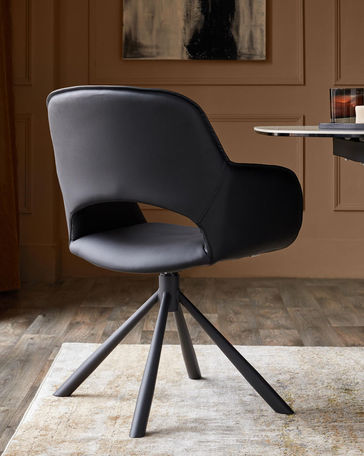 A black, modern swivel chair with a sleek design and metal legs, positioned on a patterned rug.