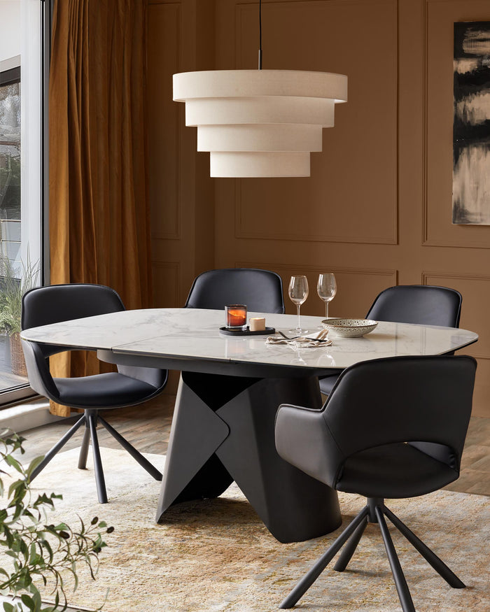 A modern dining set with a marble table, black chairs and a tiered pendant light, creating an elegant dining space.