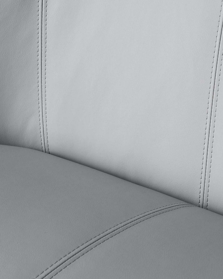Close-up of sleek grey upholstered furniture featuring subtle stitched detailing. Modern and minimalist design.