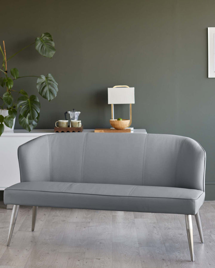 A stylish grey faux leather bench with slender metal legs, ideal for modern living spaces.