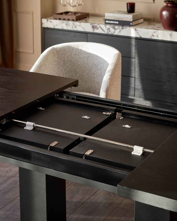 Morgan dark wood dining table with open extension leaf mechanism, showing white ceramic handles and metal hardware.