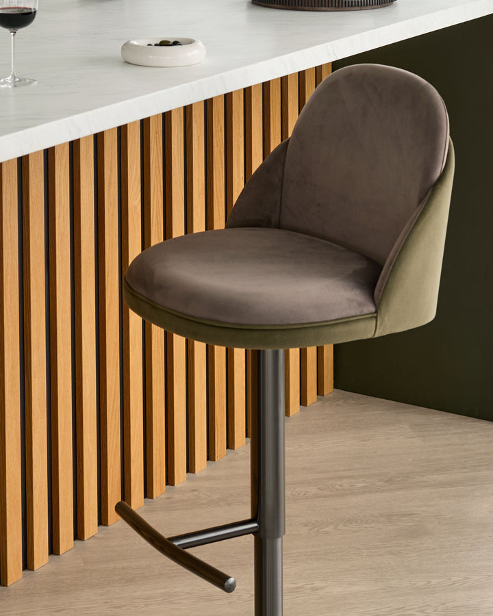 Myra gas lift bar stool in mocha velvet and olive green, shown at a kitchen counter with vertical wood slat detailing.