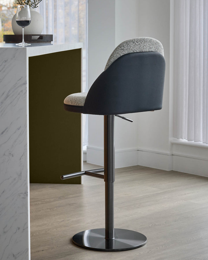 Myra gas lift bar stool in grey fabric and black faux leather, shown from side angle with chrome base and footrest.