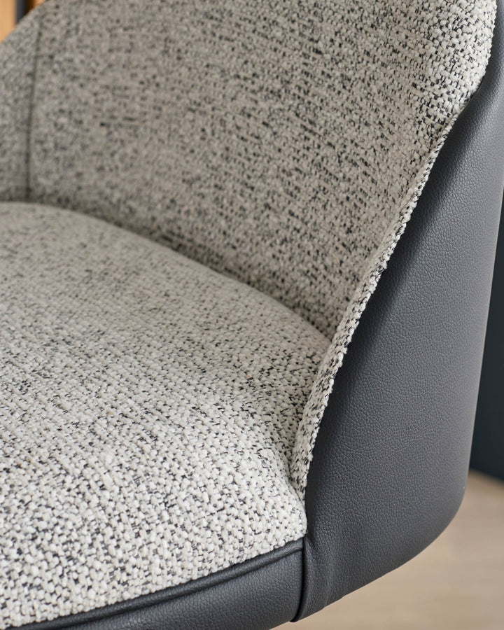 Myra gas lift bar stool with grey fabric seat and black faux leather back, close-up detail view.