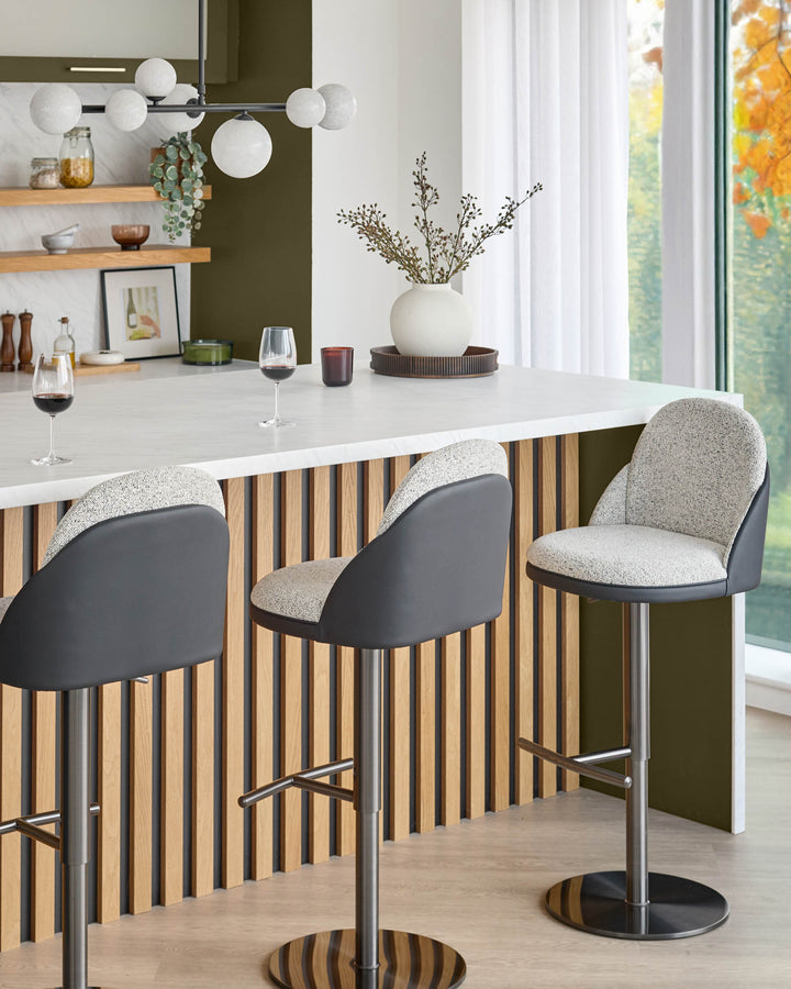 Myra gas lift bar stool with grey fabric seat, black faux leather back, and chrome base in modern kitchen setting.