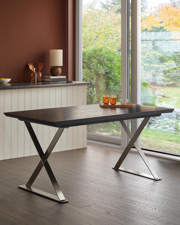 A modern dark-wood dining table with an X-shaped chrome leg design stands elegantly in a well-lit dining area.