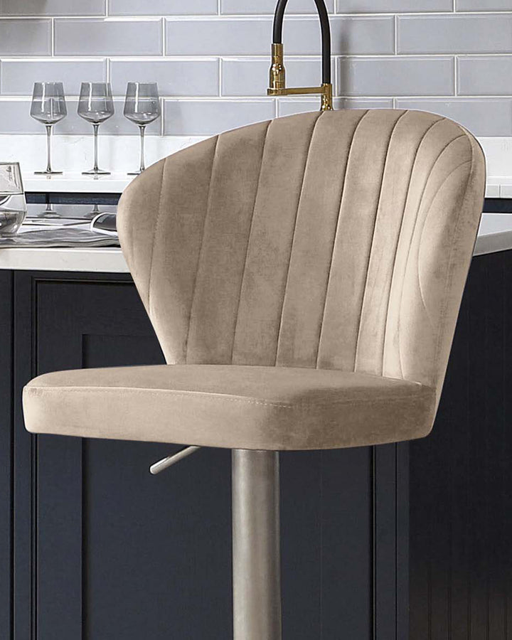 Harper champagne velvet gas lift bar stool with vertical channel back detail and brushed metal base at kitchen island.