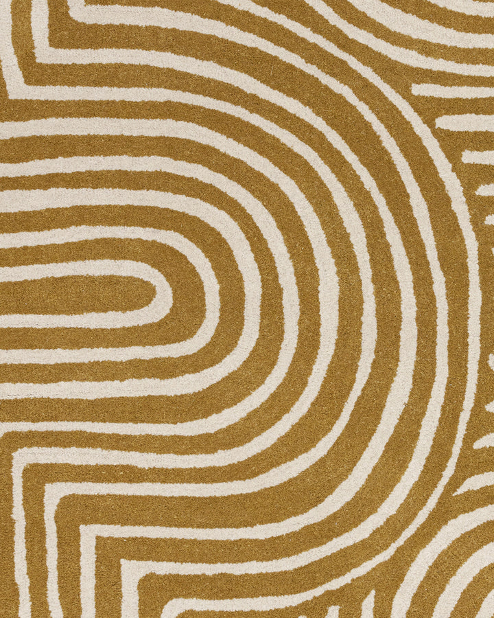 Abstract swirl medium sculpted wool rug in ochre and cream with raised textured pile detail.