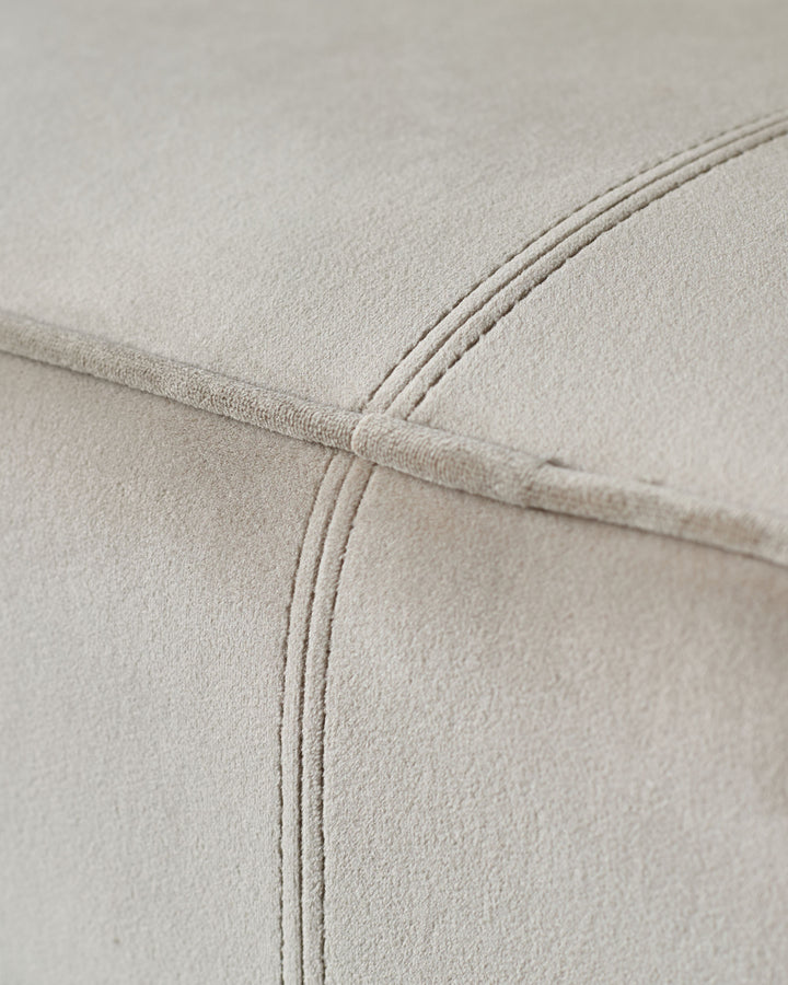 Close up of soft, light grey fabric sofa with quilted stitch detail. Stylish and comfortable.