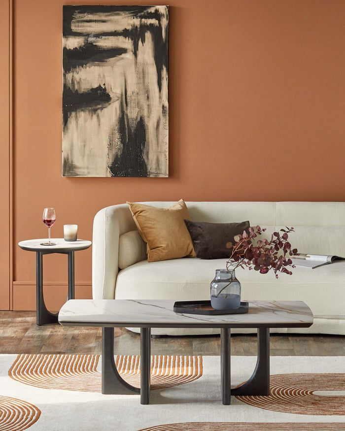 Stylish living room furniture: a marble-top coffee table, side table, and a cosy sofa against a warm terracotta wall.