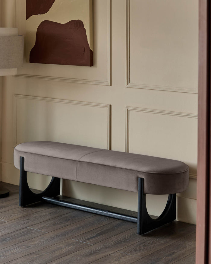 A stylish taupe velvet bench with a sleek, modern black frame adding a touch of sophistication to any space.