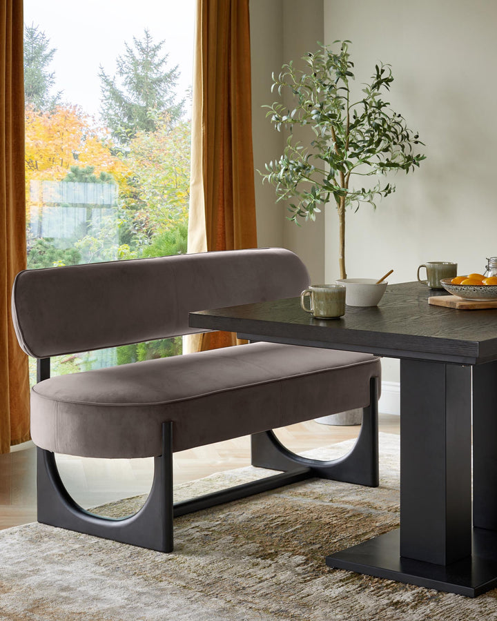 Dining room with a brown bench, a dark wood table, and a faux olive tree, creating a modern, elegant dining space.