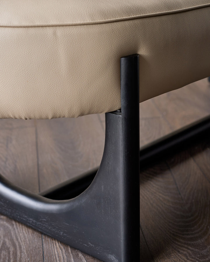 Orlan bench backrest detail showing black wooden frame and natural faux leather upholstery from side angle.