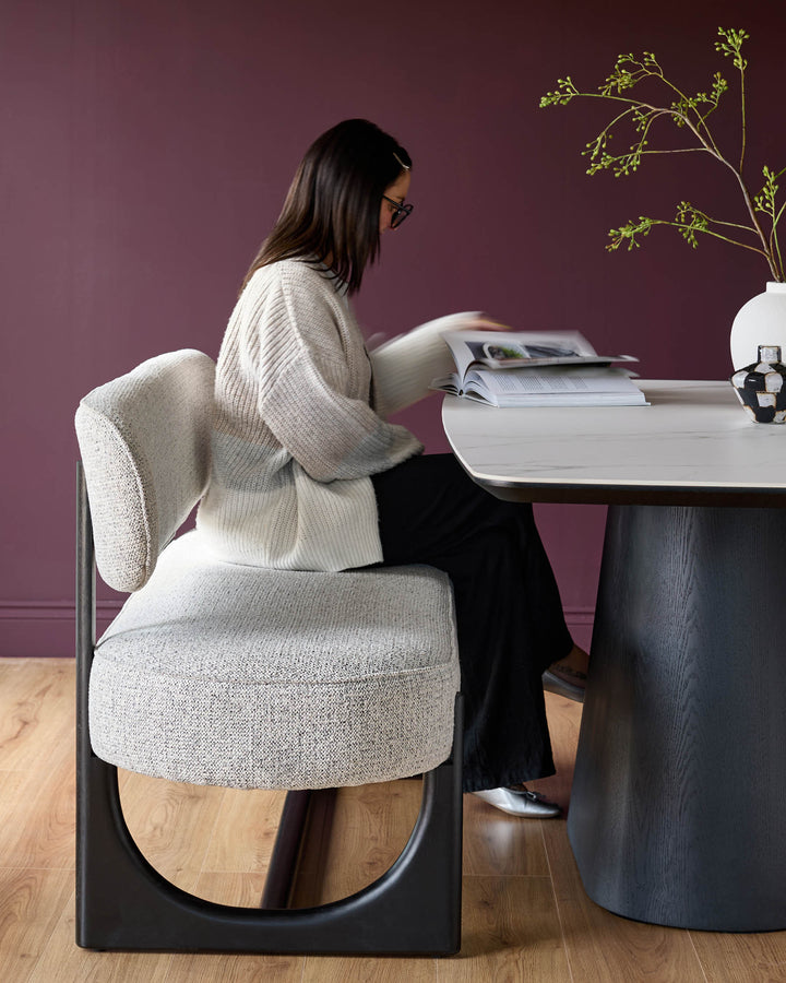 Contemporary dining set featuring a marble-effect table and stylish grey upholstered bench with black frame, offering a modern look.