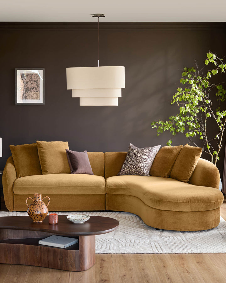 Ochre fabric right-hand corner chaise sofa with curved design and decorative cushions in a dark modern living room.