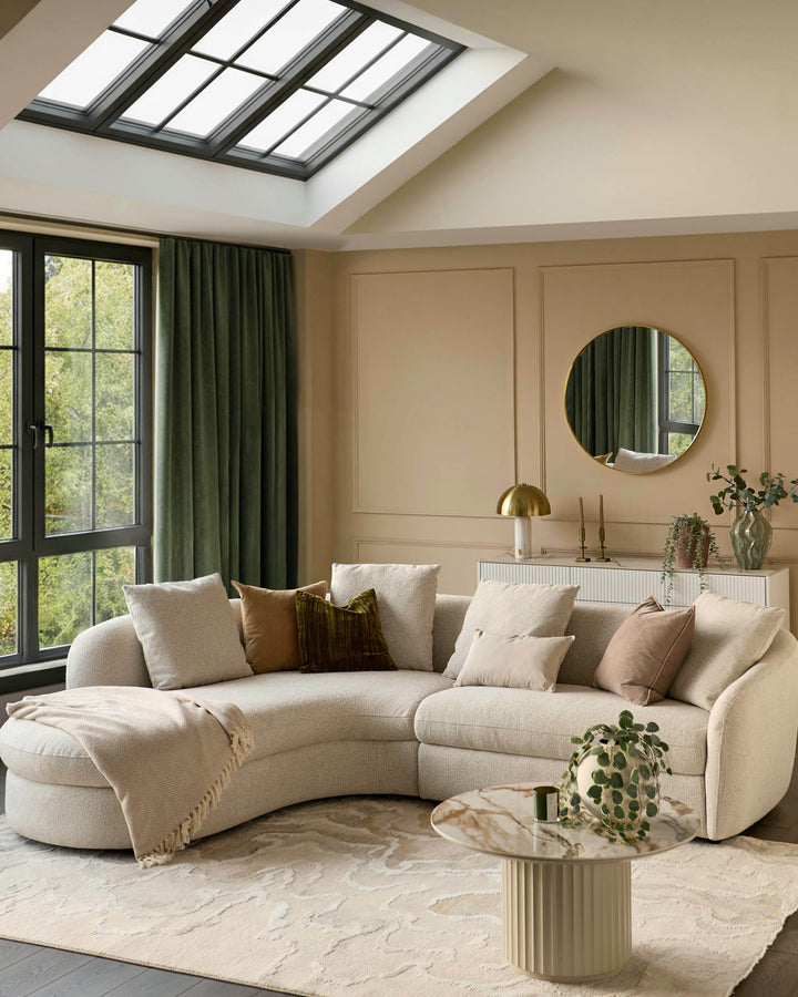 Ottilie left-hand corner chaise sofa in natural fabric, curved design with rounded arms, displayed in a modern living room setting.