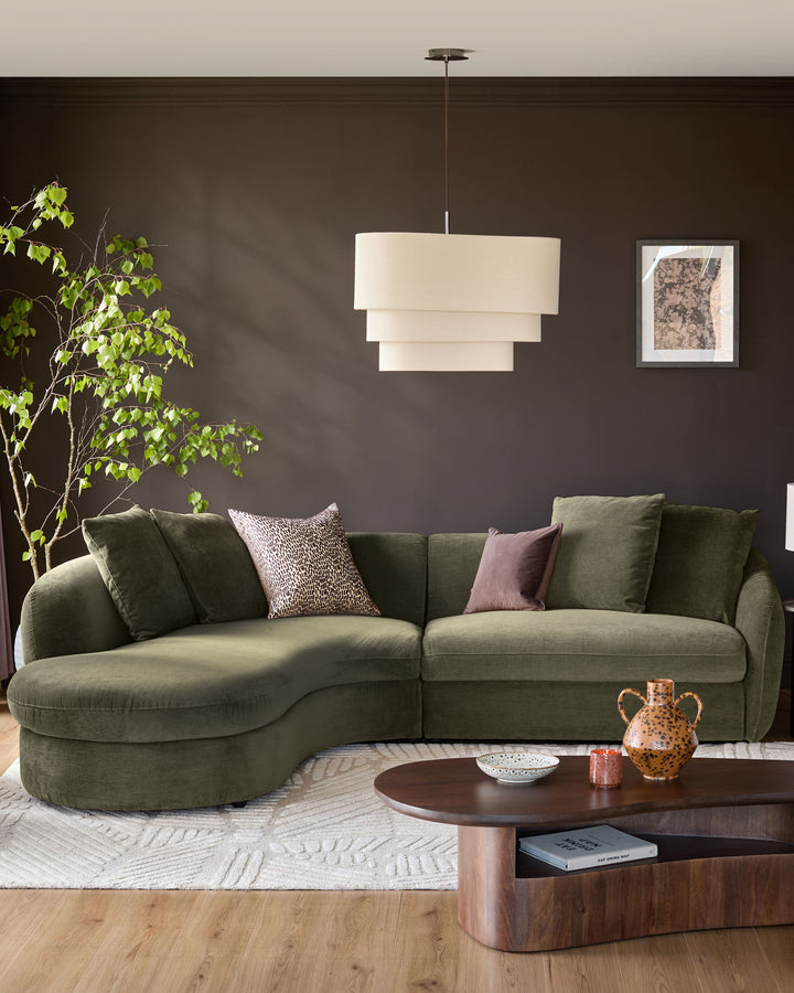 Olive green left-hand corner chaise sofa with curved armrests and plush cushions, styled in a modern living room setting.