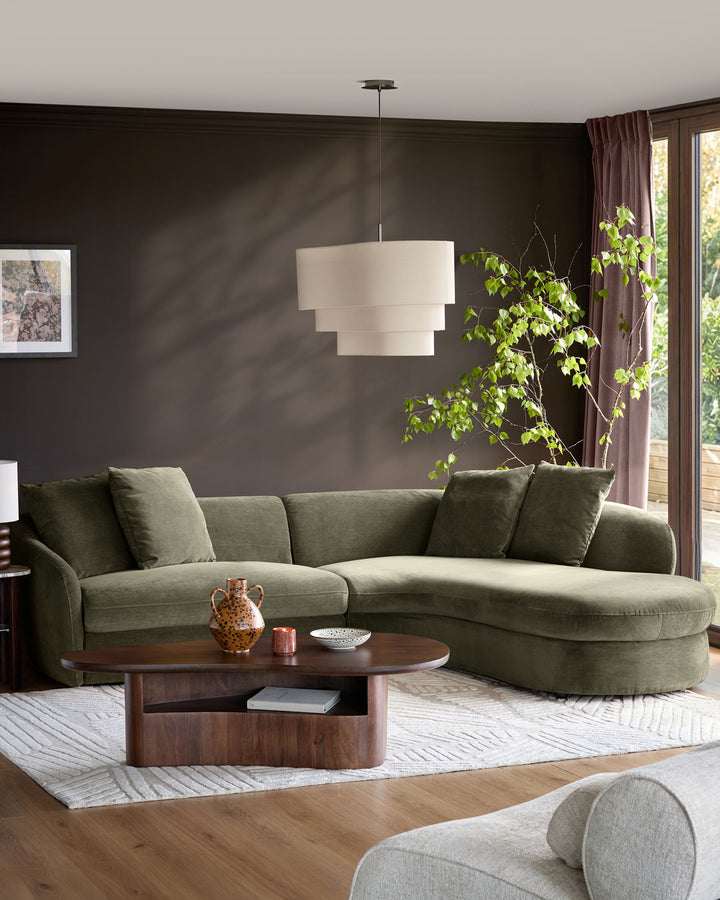Ottilie right-hand corner chaise sofa in olive green fabric, displayed in a modern living room setting with dark walls.