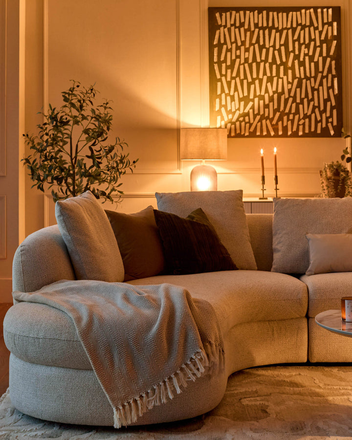 Ottilie left-hand corner chaise sofa in natural fabric, curved design with rounded armrests, styled in warm-lit living room setting.