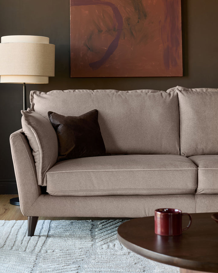 Otto 3-seater sofa in mocha fabric, angled view showing rolled arms, piped edges, and tapered legs with scatter cushions.