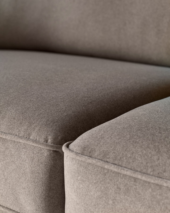 Close-up detail of Otto 3-seater sofa in mocha fabric, showing cushion seams and soft upholstery texture.