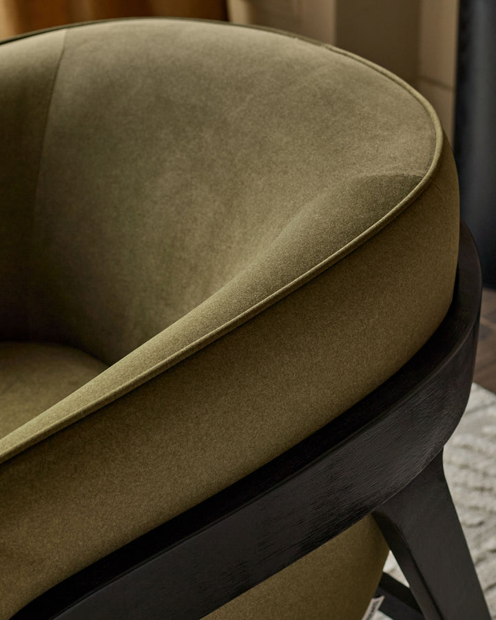Palmer occasional chair in pistachio green fabric with black wooden frame, angled side view detail.