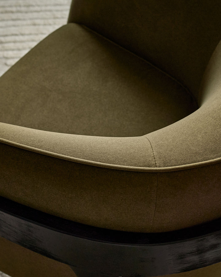 Palmer occasional chair in pistachio green fabric, showing curved armrest and seat detail with dark wooden base.