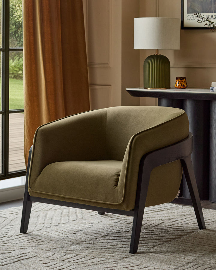 Palmer occasional chair in pistachio green fabric with black wooden legs, positioned in a styled room setting.