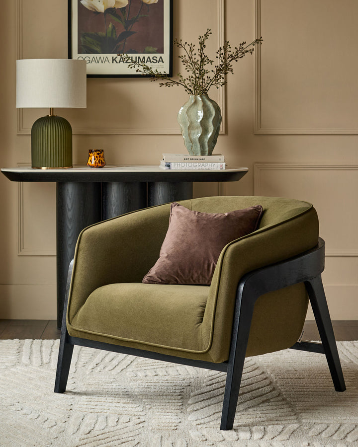 Palmer occasional chair in pistachio green fabric with black wooden legs, styled in a modern living room setting.