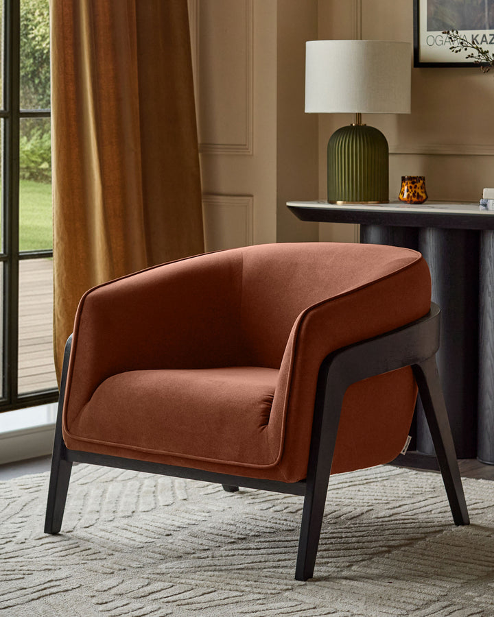 Palmer Occasional Chair in toffee-red fabric with black wooden legs, shown in a styled living room setting.
